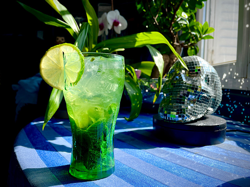 Un verre de mojito avec feuilles de menthe, glaçons et rondelle de citron vert sur la table du salon
