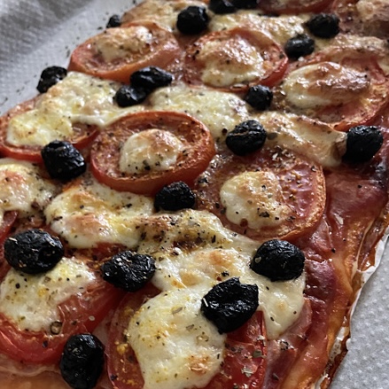 Pizza avec tomate, mozzarella, jambon, olives, origan