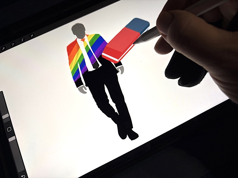 Sur une tablette graphique, on voit une main qui dessine une gomme qui efface un rainbow flag d'une silhouette en costme-cravate