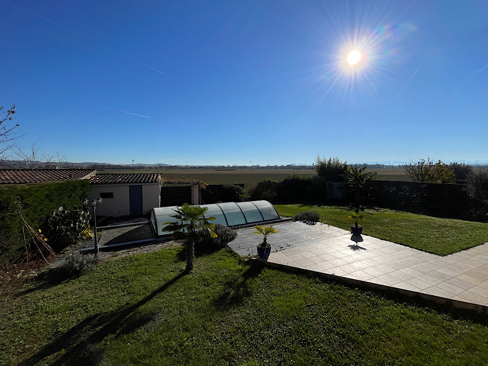 Jardin sous le soleil, ombre allongée, soleil bas, grand ciel bleu