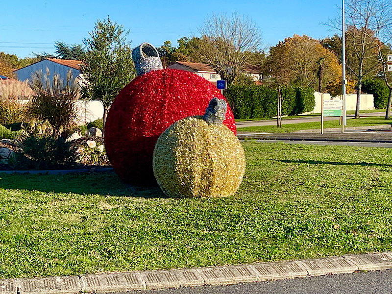 Deux grosses boules de décoration de Noël sur un rond point du village