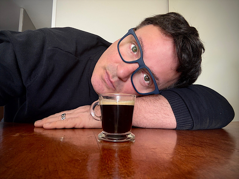 Selfie tête posée sur la table devant une tasse de café